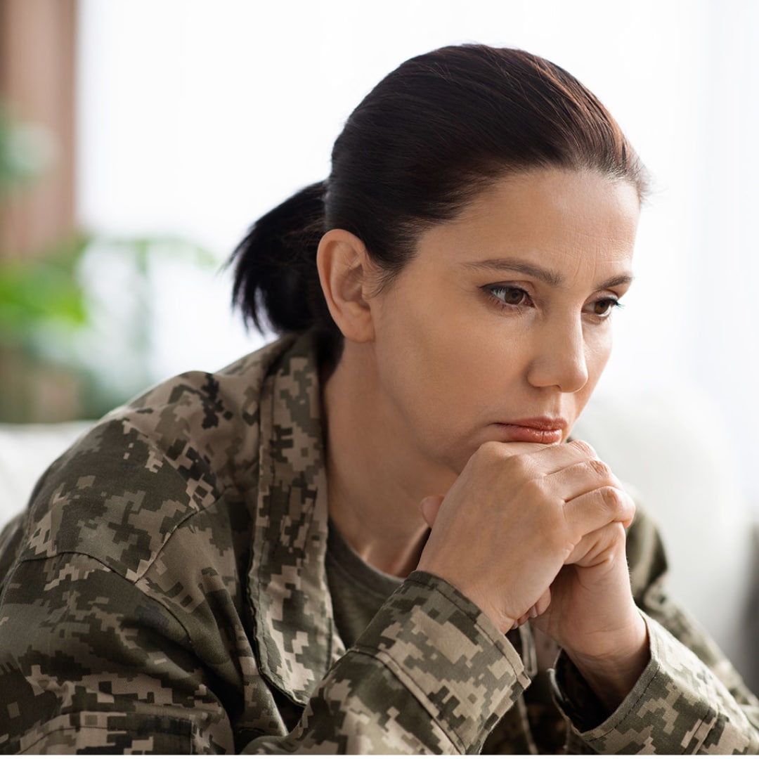 Woman in fatigues working with a PTSD therapist online.