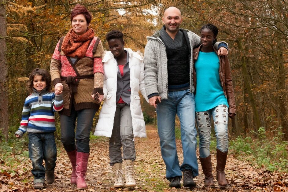 A happy family taking a walk in nature with fall colors after family counseling.