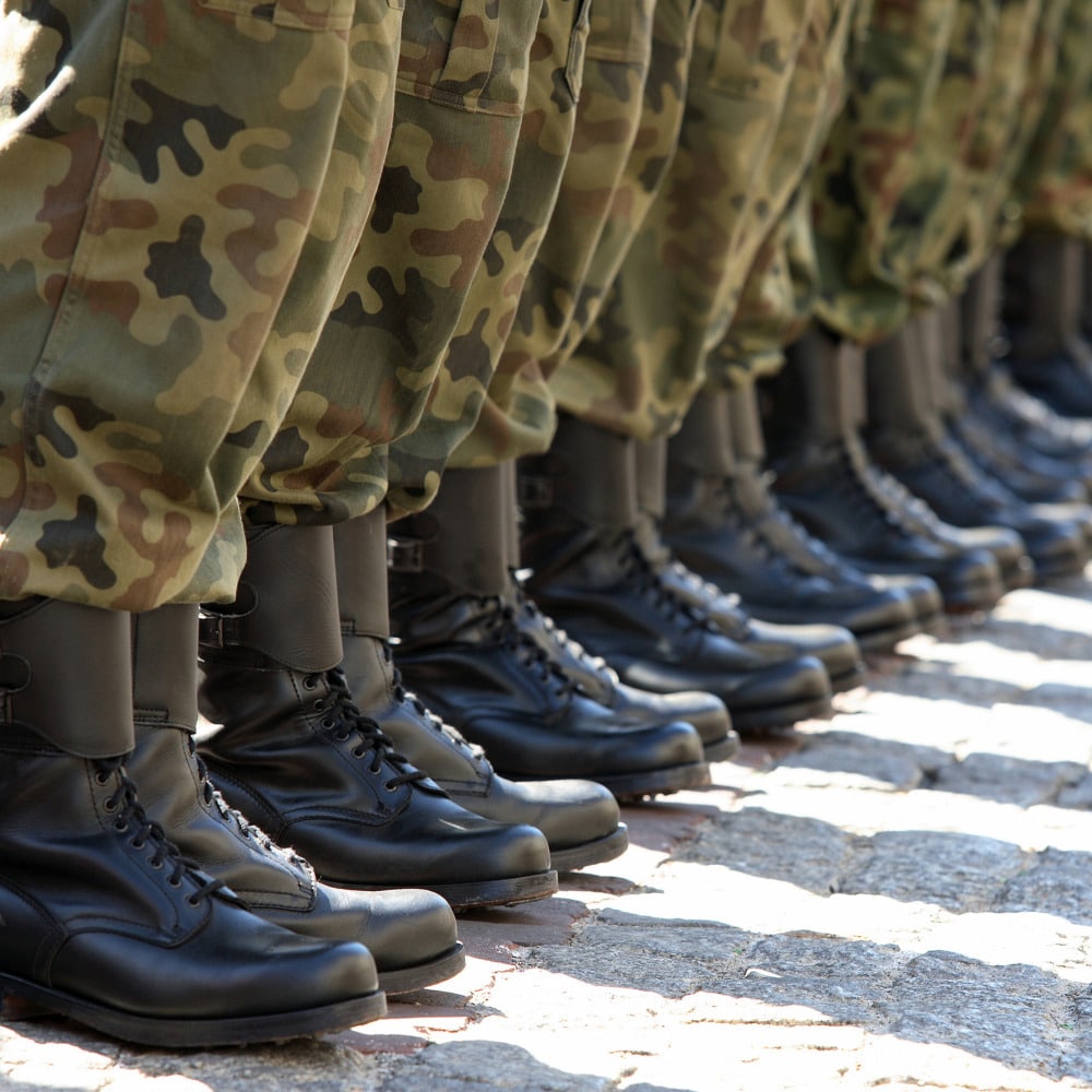 A row of military personnel with combat boots eligible for ptsd therapy online for veterans.